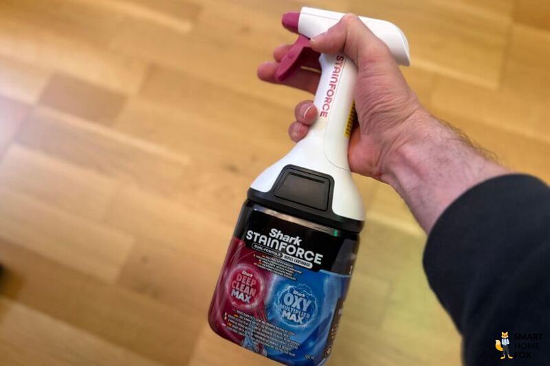 Mit der separaten Shark Stainforce Sprühflasche wird der Fleck vorbehandelt und eingesprüht.